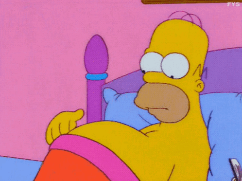 Homer Simpson lies in bed looking hungry.