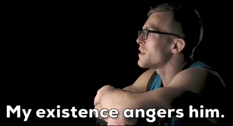 A man looks upward beside the caption “My existence angers him.”