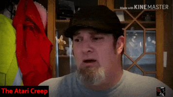 a man with a beard wearing a hat is making a funny face with the words the atari creep in the bottom right