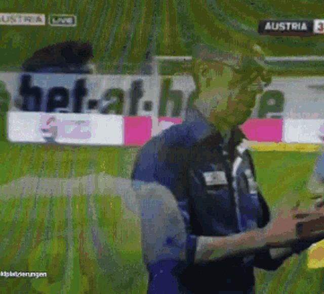 a blurred image of a man on a soccer field with a bet-at.be sign in the background