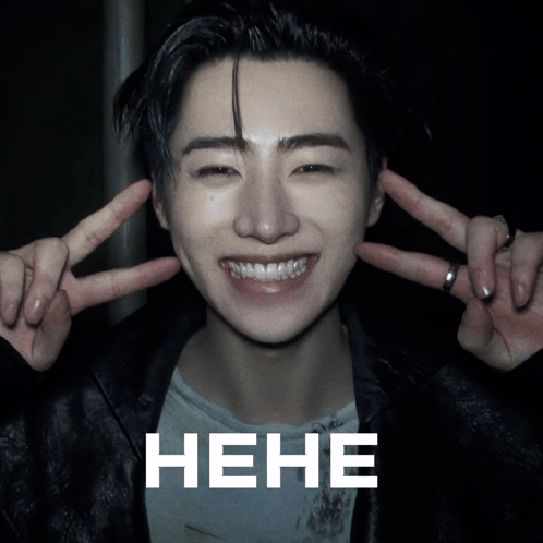 a man making a peace sign with his fingers behind his ears and the word " hene " in white