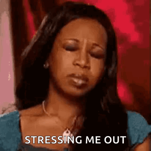 A woman closes her eyes and rubs her head, captioned “STRESSING ME OUT.”