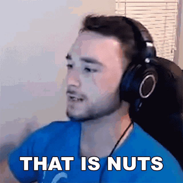 a man wearing headphones says " that is nuts " in front of a window
