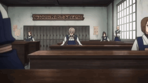 a group of people are sitting at desks in a classroom with a sign on the wall that says ' ae2 '