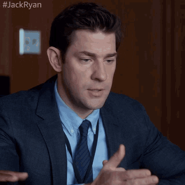 a man in a suit and tie with #jackryan written on the bottom right