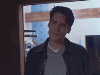 a man in a jacket is standing in a doorway looking at the camera .