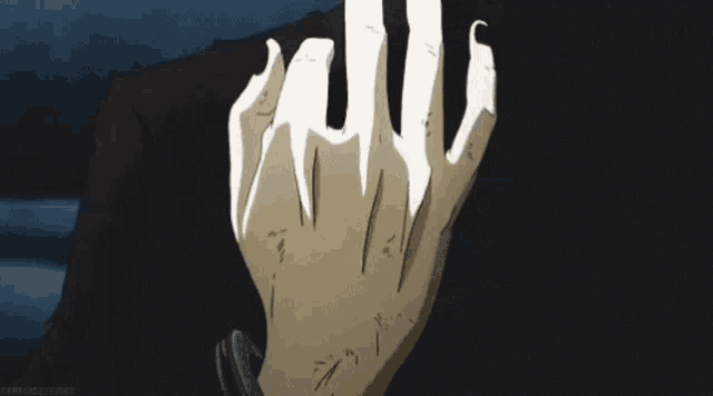 a close up of a person 's hand with long nails and a black shirt .