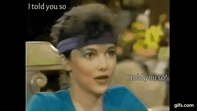 a woman wearing a headband and a blue shirt is talking to another woman .