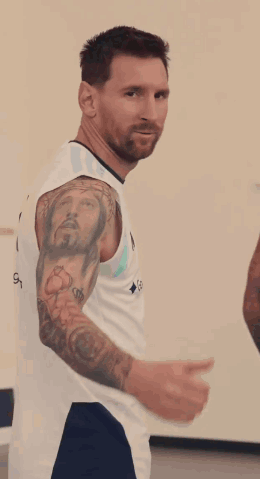 A soccer player in an Argentina jersey turns around and gives a thumbs-up.