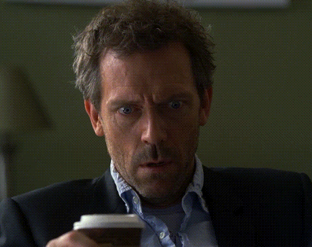 a man in a suit holds a cup of coffee in his hand
