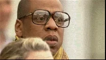 A man in glasses gives a tense, awkward laugh.
