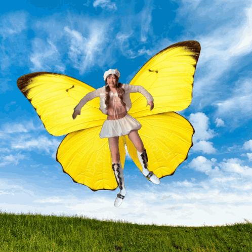 a woman in a white skirt is flying in the air with a butterfly wing