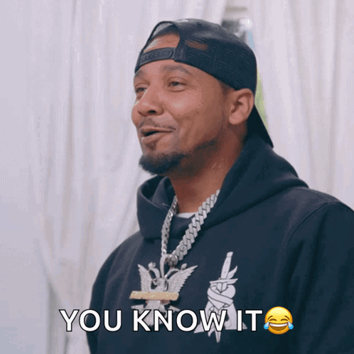 a man wearing a black hoodie and a hat is saying you know it