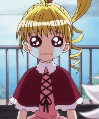 a little girl with a red cape is crying with her eyes closed