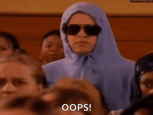 A person in sunglasses and a purple hood sits awkwardly in an audience beneath “OOPS!”