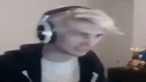 A blurry headset-wearing streamer reacts with wide eyes.