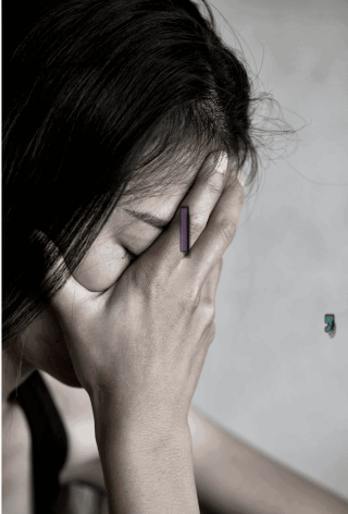 A woman covers her face with one hand in visible distress.