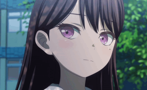 a girl with long dark hair and purple eyes looks at the camera
