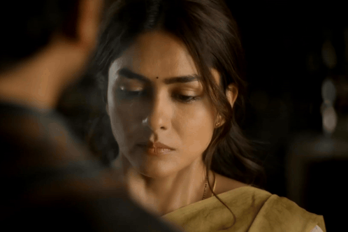 a close up of a woman 's face with a yellow saree