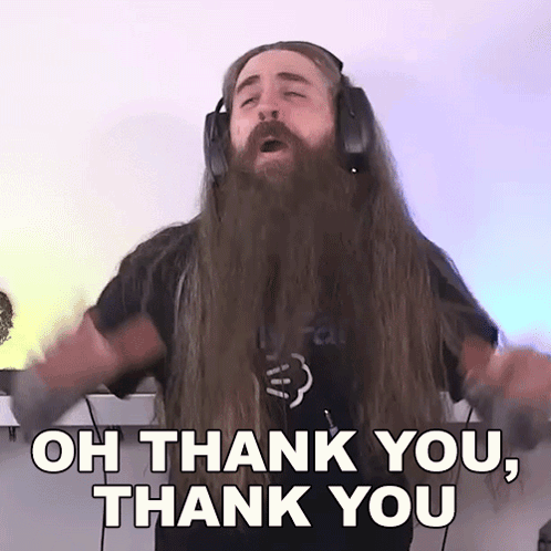 a man with long hair and a beard is wearing headphones and saying oh thank you thank you .