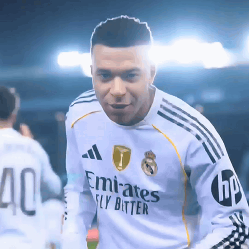a soccer player wearing a white emirates fly bitter jersey