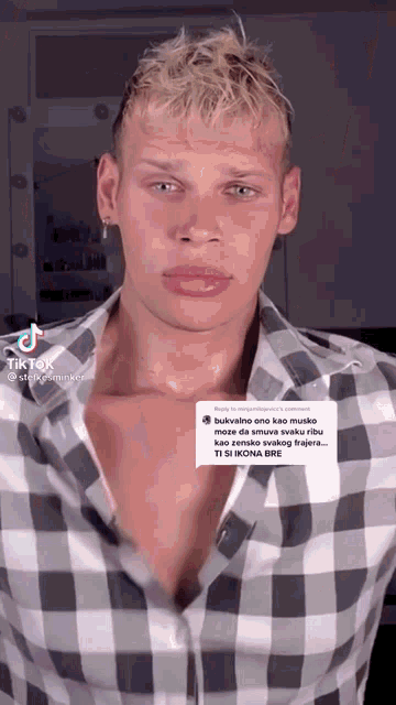 a man wearing a plaid shirt has a tiktok sticker on his shirt