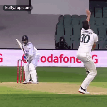 a cricket player with the number 30 on his back is throwing a ball