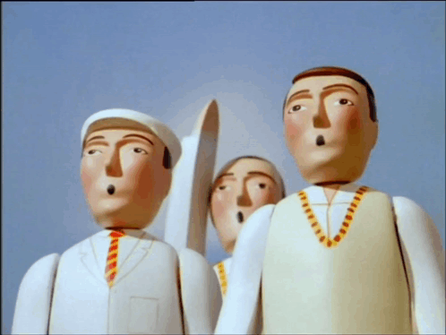 a group of wooden dolls are standing next to each other and one has a surprised look on his face