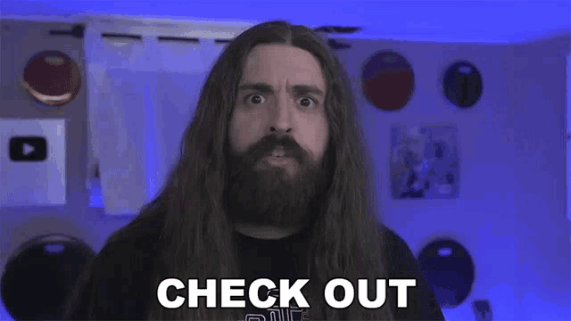 a man with long hair and a beard is making a funny face and says `` check out '' .