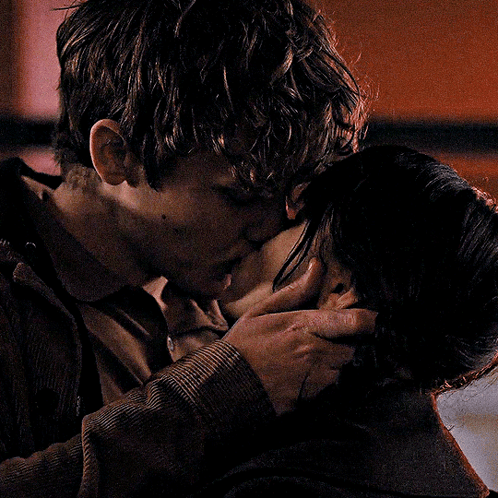 a man and a woman kissing in a dark room