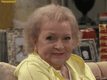 An elderly woman gives a knowing smile.