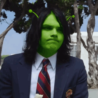 a man in a suit and tie with a green face