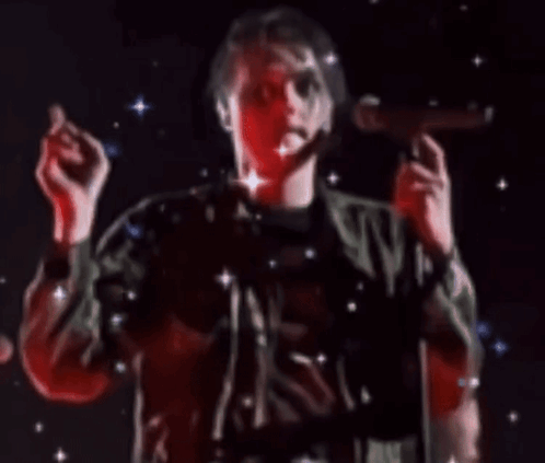 a man in a green jacket singing into a microphone with stars in the background