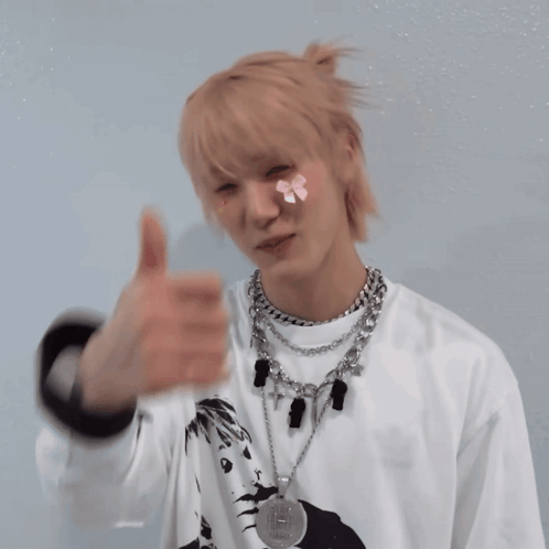 a man giving a thumbs up with a yellow sticker on his face