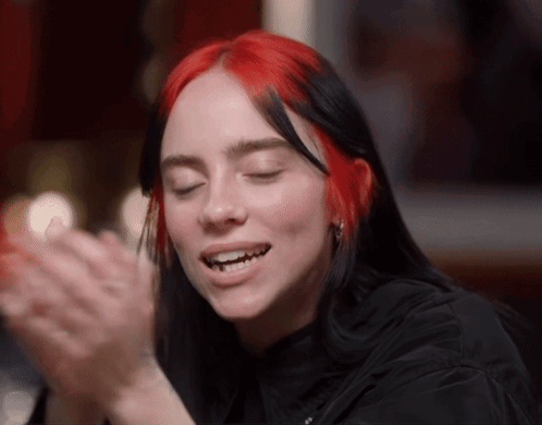 a woman with red hair is clapping her hands