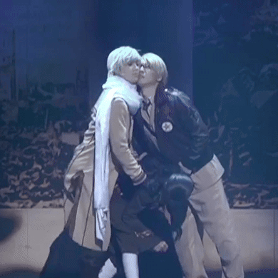 a couple of people are kissing on a stage .