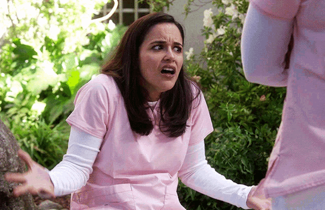 Amy Santiago throws up her hands in a confused shrug outdoors.