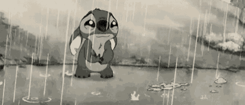 Stitch sits alone in the rain looking sad and drenched.
