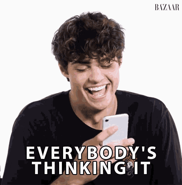 a man is laughing while looking at his phone with the words everybody 's thinking it behind him