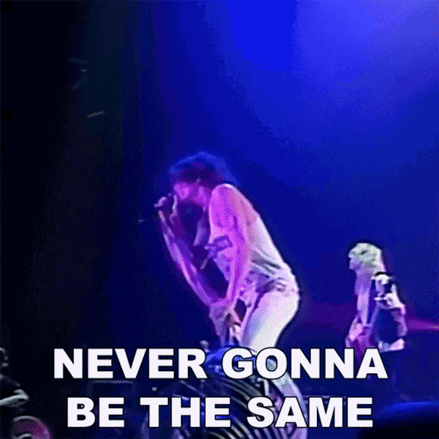 a man singing into a microphone with the words " never gonna be the same " next to him