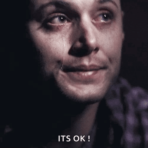 A tearful man looks off to the side against a dark background.