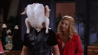 a man with a turkey on his head standing next to a woman