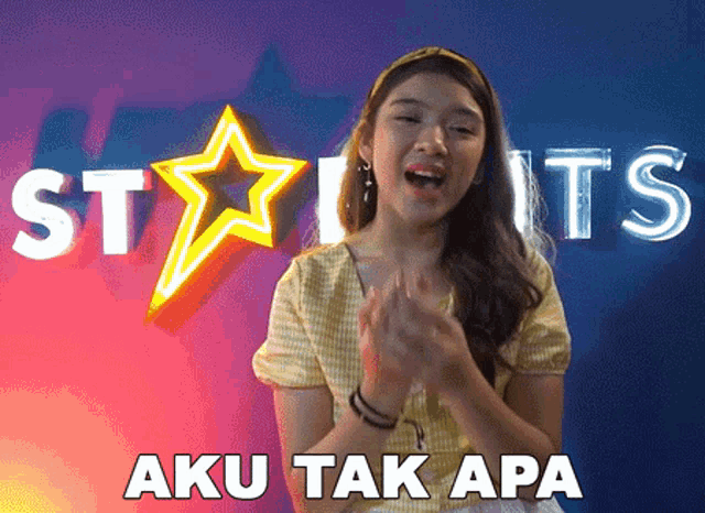 a girl is clapping in front of a sign that says stars