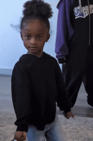 A child gives a cool sideways look while rolling their shoulders.