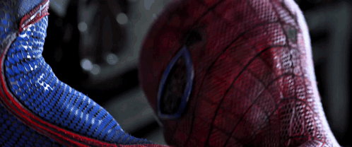 a close up of a spider man 's face with a blue and red pattern
