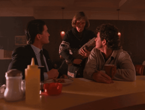 three people sitting at a table with one saying " one day my log will have something to say about this .. "