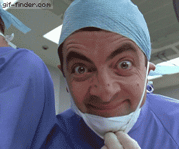 Mr. Bean in surgical clothing gives a thumbs up close to the camera.