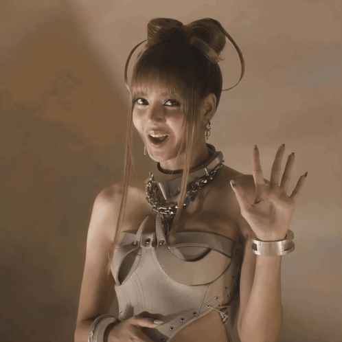 A woman in a metallic costume waves at the camera.
