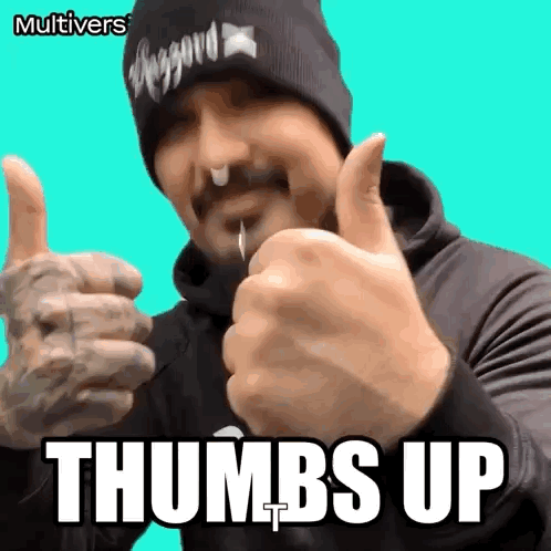 A man in a cap points both thumbs up toward the camera under “THUMBS UP.”