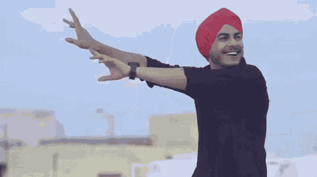 a man wearing a turban and a black shirt is dancing